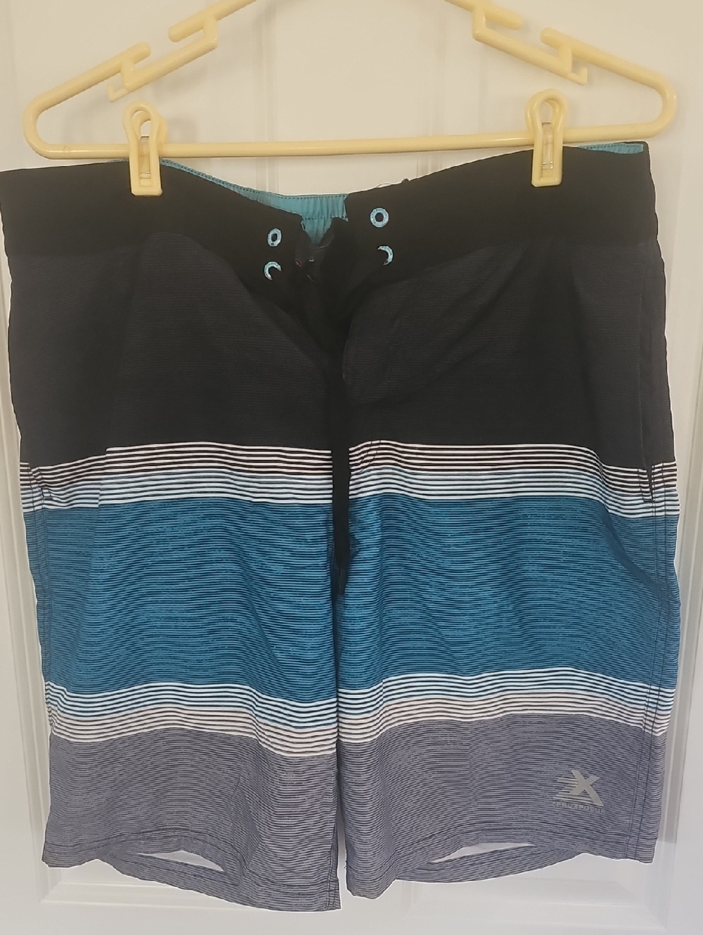 ZeroXposur Swimwear Tag with Teal Accent and Gray Print